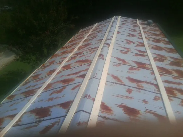 Rusted metal roof panels with new wood purlins before replacement — Storm Damage Roof Repair in Boyden by Roofing Brothers